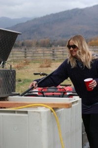 Mimosa in one hand and rake in another, Ian Schroth's friend helps with the de-stemming process.